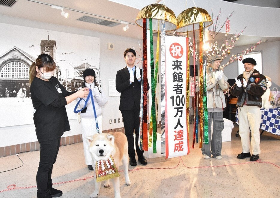 来館者１００万人を記念し、くす玉を割った宋怡さん（左から２人目）や石田健佑市長（同３人目）ら＝秋田県大館市で２０２４年１２月２７日、田村彦志撮影