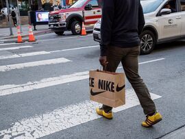 A shopper carries a Nike bag in San Francisco. Photographer: David Paul Morris/Bloomberg