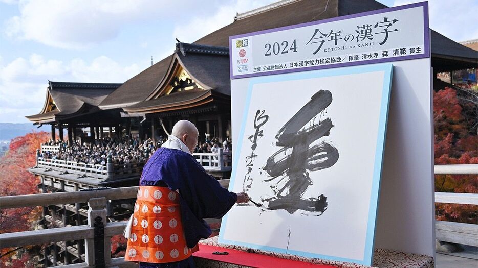 「今年の漢字」に選ばれた「金」を揮毫する清水寺の森清範貫主＝2024年12月12日、京都市東山区（時事）