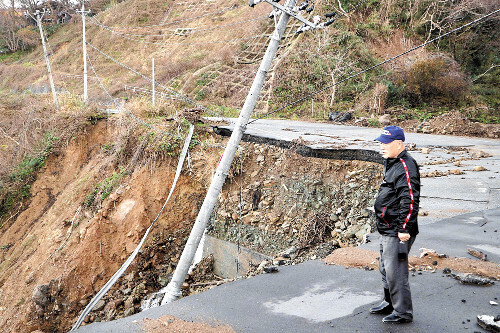 大きく崩れ落ちた道路に肩を落とす中さん（２日、石川県輪島市で）