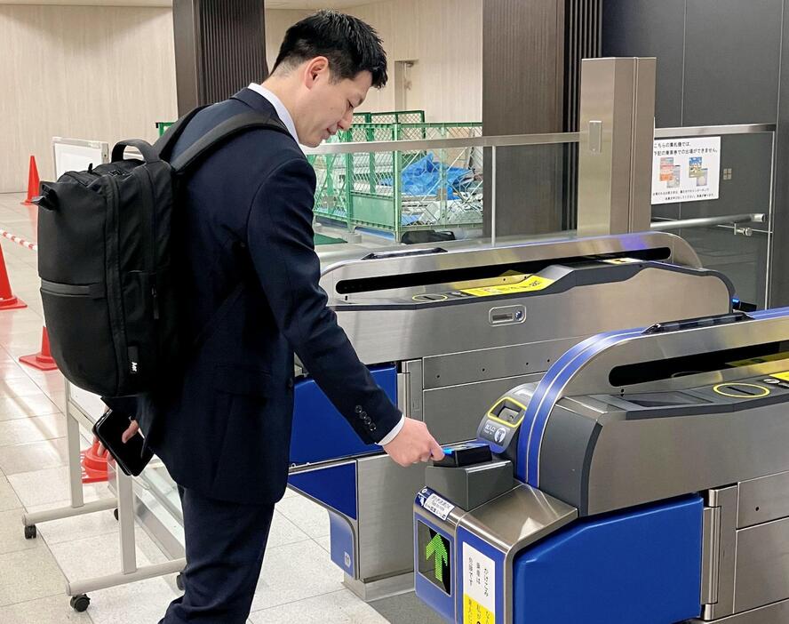 クレジットカードのタッチ決済で駅の自動改札機を通るイメージ