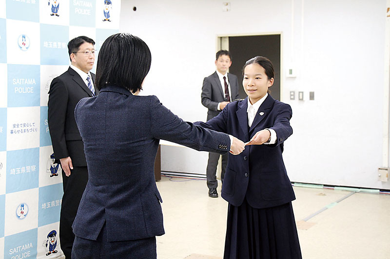 県警の羽石千代警務部長（左）から表彰状を受け取った弘山真菜さん＝16日、県警本部