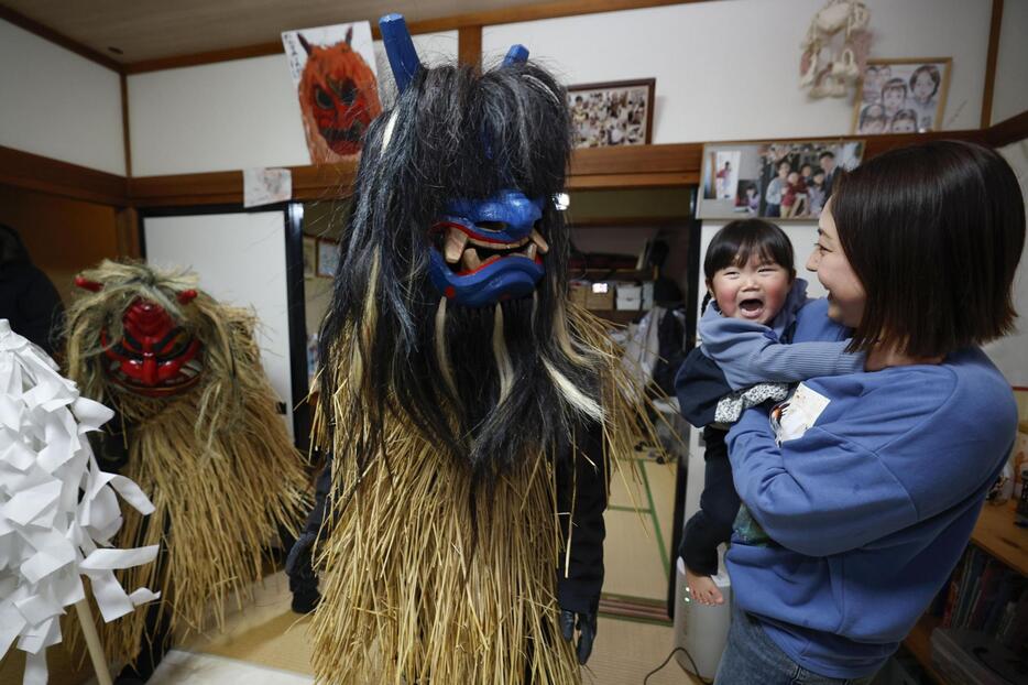 池田亮一さん宅を訪れたナマハゲに驚く次女の千真梨ちゃん（右から2人目）＝31日夜、秋田県男鹿市