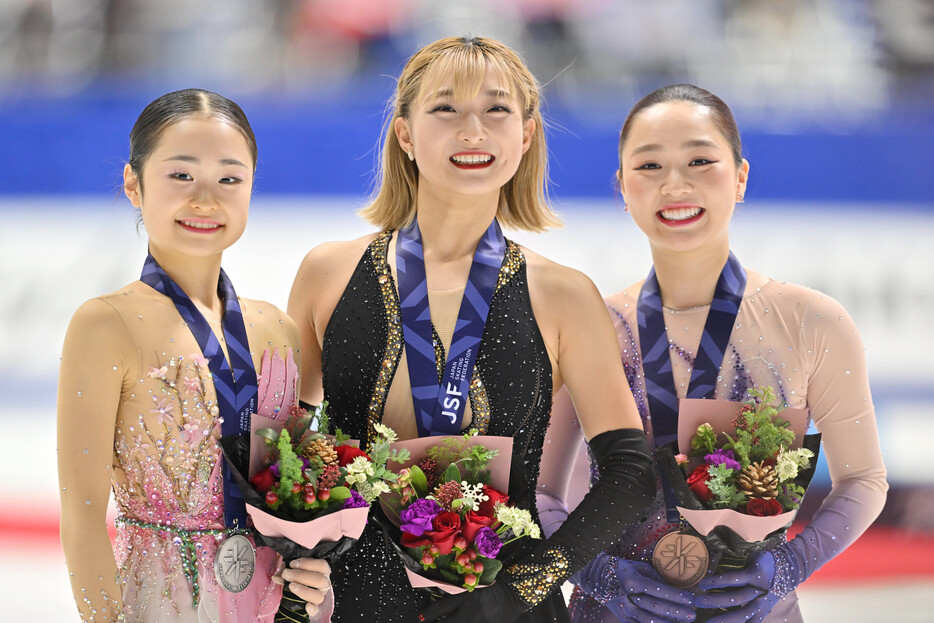 フィギュアスケートの全日本選手権女子で４年連続５度目の優勝を果たした坂本花織（中央）。左は２位の島田麻央、右は３位の樋口新葉＝２２日、大阪・東和薬品ラクタブドーム