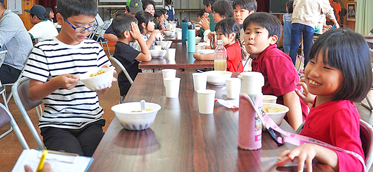 子ども食堂(チキンカレー)に笑顔の参加者たち＝徳之島町亀津