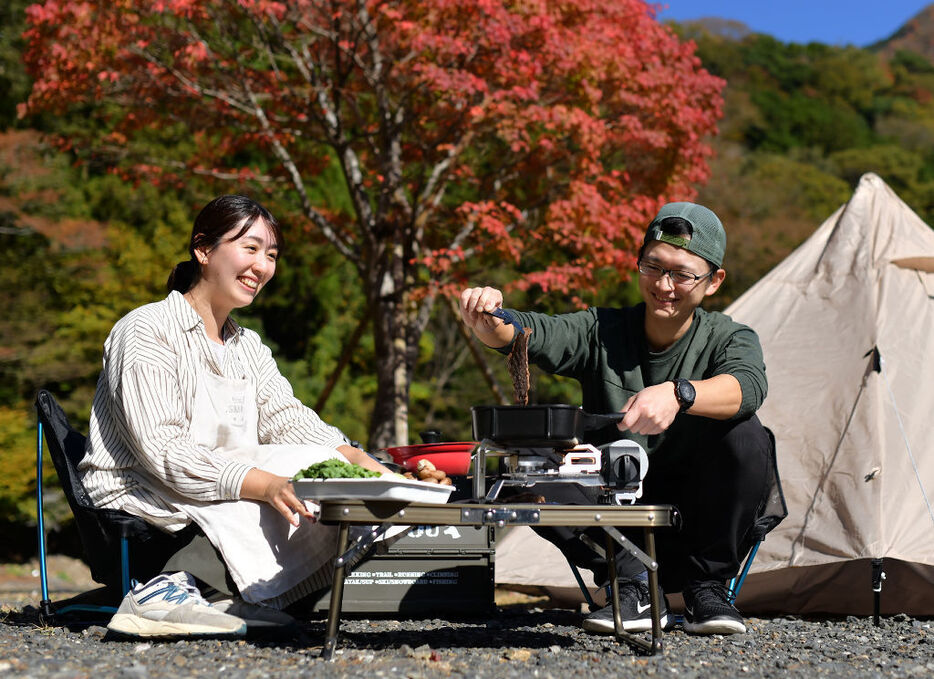 牛肉のわさび漬けロールすきやきを調理する藤山達広さん（右）と坂尾友希さん＝静岡市葵区の黄金の里湯CAMP