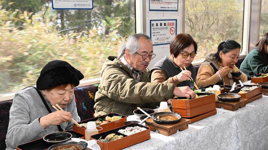 車窓の景色を楽しみながらしし鍋を味わう乗客＝本巣市、樽見鉄道