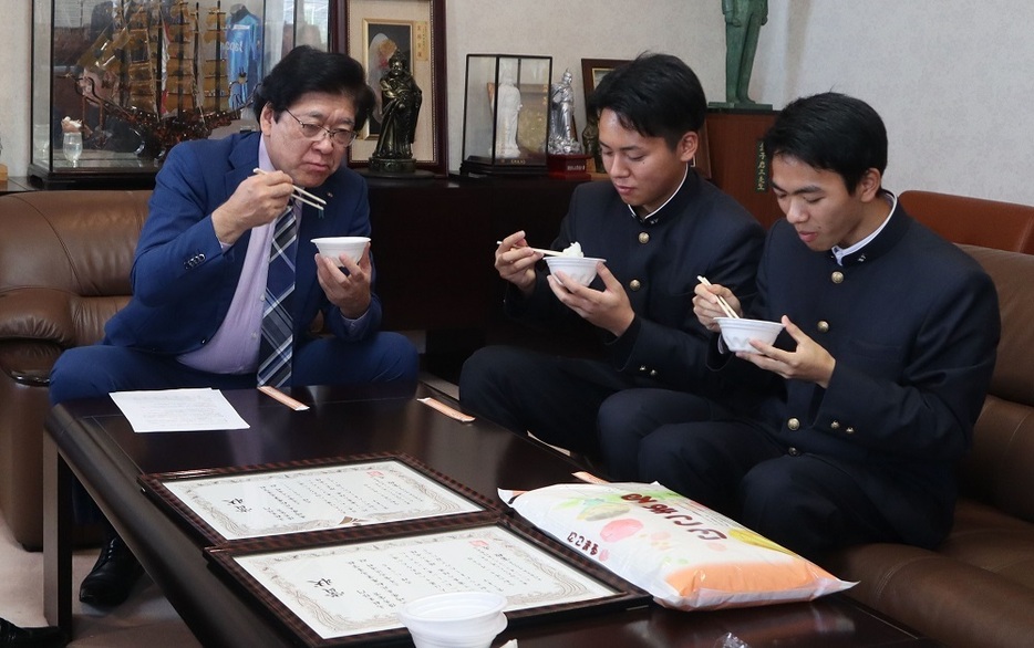 優秀金賞の「にこまる」を試食する（左から）黒田市長、辻村さん、武久さん＝平戸市役所