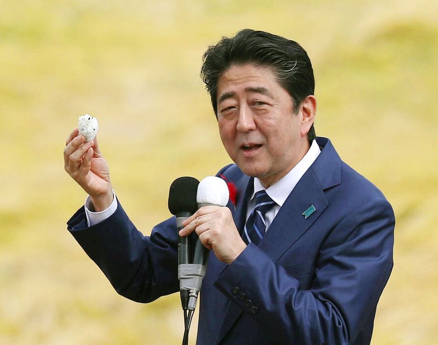 衆院選の応援演説でおにぎりを試食する安倍首相（当時）＝2017年10月、福島市 - 写真提供＝共同通信社