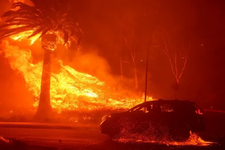 カリフォルニア州ロサンゼルス郡マリブにあるペパーダイン大学で、山火事の横を通り過ぎる車