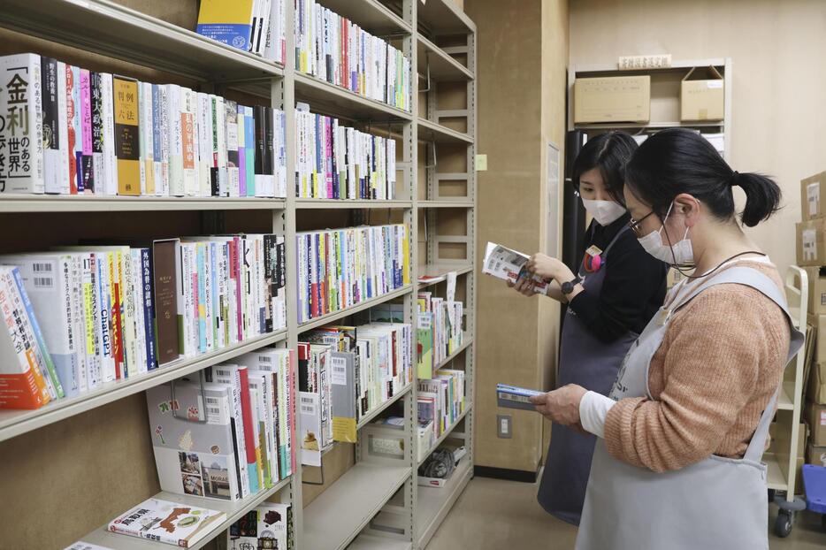 地元書店から鳥取県立図書館に運び込まれた本を選ぶ職員＝2024年11月12日、鳥取市