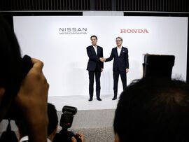 Makoto Uchida, left, and Toshihiro Mibe pose for a photograph during a joint news conference in Tokyo, on Aug. 1.