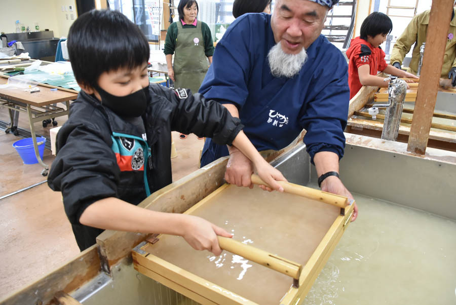 卒業証書用の和紙をすく児童