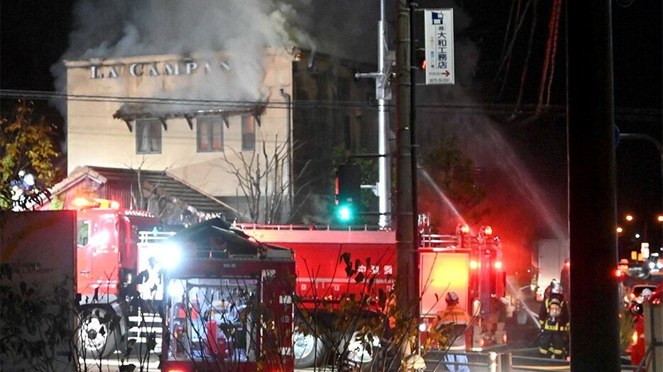 白煙を上げて炎上する建物＝１３日午後６時５０分、関市虹ケ丘南