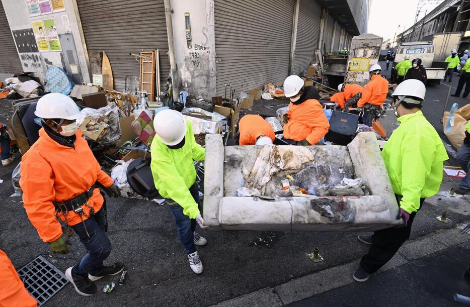 「あいりん総合センター」での野宿者らに対する強制執行が着手され、荷物を撤去する作業員ら＝1日午前、大阪市西成区のあいりん地区