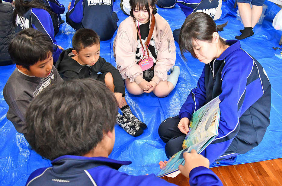 海洋プラスチックについて児童に読み聞かせをする奄美高生（21日、宇検村の平田公民館）