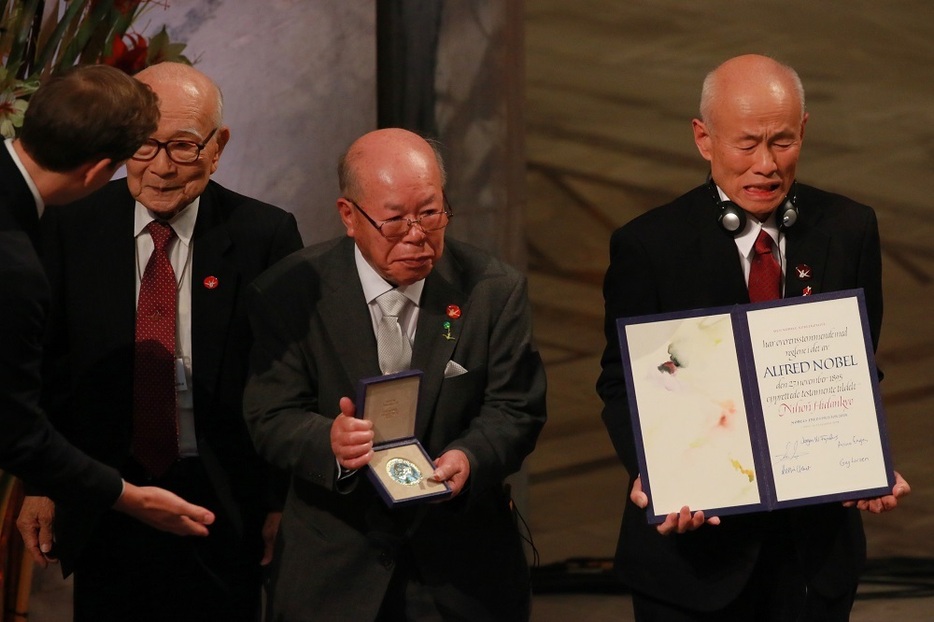 授賞式で賞状を受け取った箕牧さん（右）とメダルを手にする田中重光さん（中央）、演説をした田中熙巳さん＝ノルウェー・オスロ市庁舎