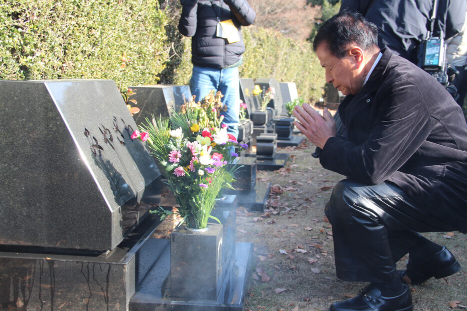 宮沢みきおさん一家の墓前に手を合わせる元警視庁成城署長の土田猛さん＝３０日午前、埼玉県新座市