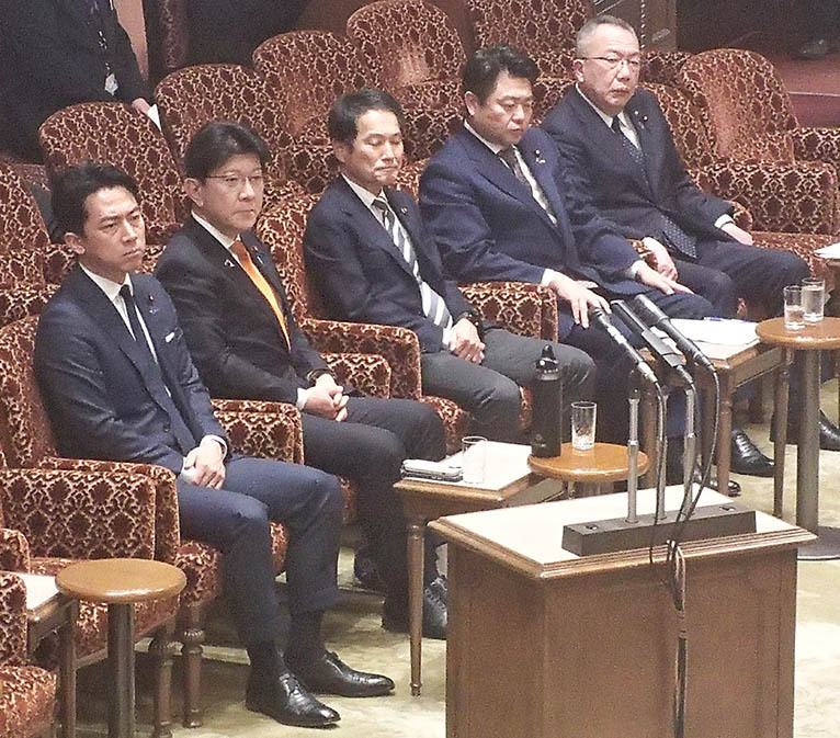 提案者の１人として厳しい表情で野党の討論を聞く小泉氏（左）＝参院委員会室