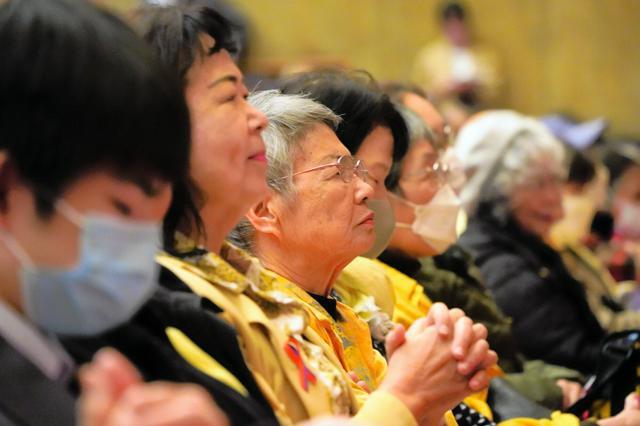 県民大会に参加した人たち。ミモザを連想させる黄色のリボンやマフラーなどを身につけて集まった=2024年12月22日午後2時38分、沖縄県沖縄市の沖縄市民会館、棚橋咲月撮影