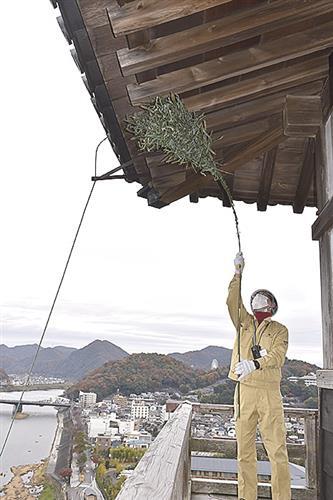 軒下のほこりを払う職員