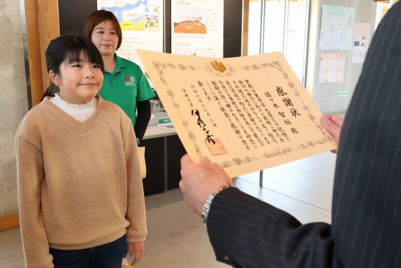 母親の智恵さん（中央）と共に復興庁から感謝状を贈呈された佐々木智桜さん（左）＝岩手県釜石市で2024年12月20日午後2時5分、奥田伸一撮影