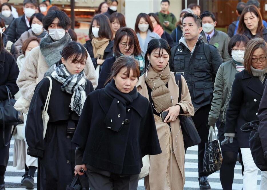 マフラーやコートなどで防寒対策をして出勤する人たち＝１０日午前、神戸市中央区、ＪＲ元町駅前（撮影・笠原次郎）