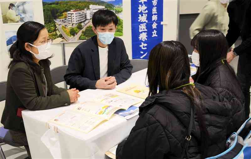 参加した学生ら（右）に説明する病院の担当者＝15日、熊本市中央区