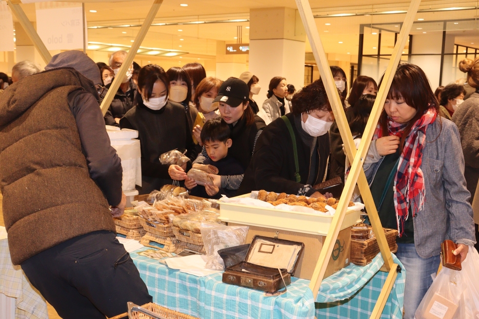 目当ての品を求めて品定めする買い物客=岡山県津山市で