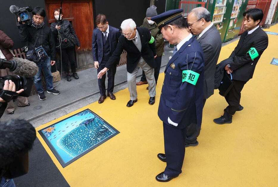 水族館の絵を見て回る曽根崎防犯協会の藤野雅文さん（中央左）ら＝10日午後、大阪市北区（泰道光司撮影）