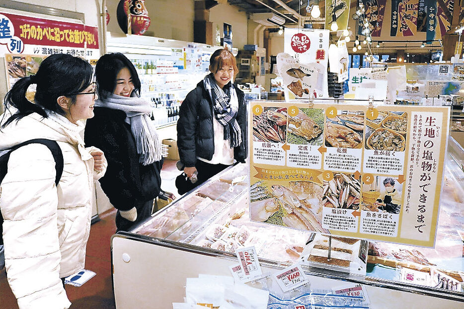 作成したポップが掲示された売り場を見て回る（手前から）宮原さん、梅田さん、森さん＝黒部市の魚の駅「生地」