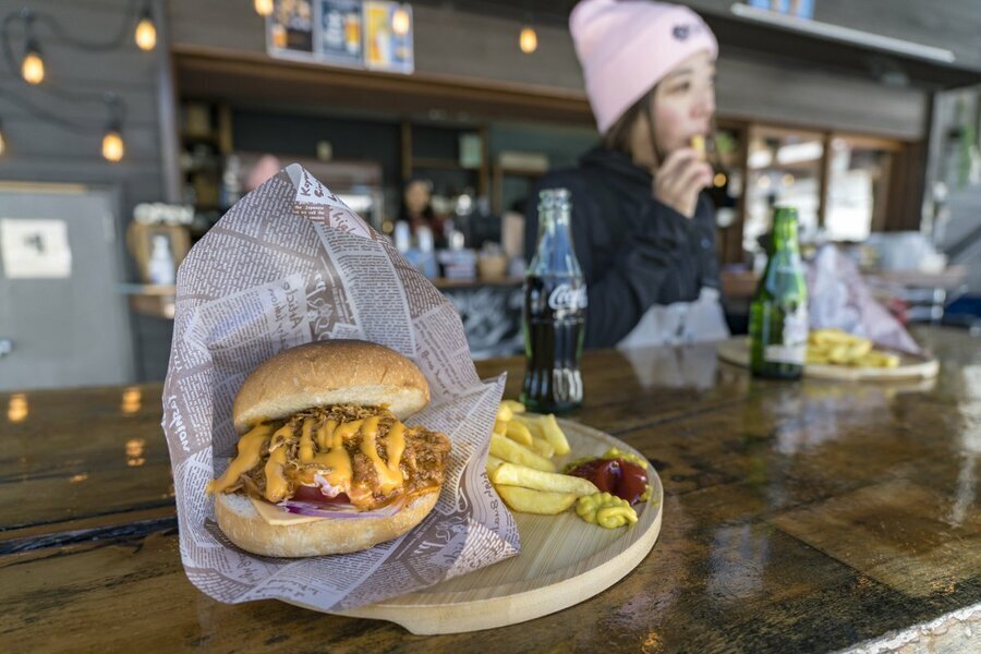 TSUGABASE（つがベース）のプルドポークバーガーに野菜などをトッピングした看板メニュー”ツガバーガー”（ポテトセット、税込1,650円）。香ばしく焼き上げられたバンズに挟まれたジューシーな具材を頬張る幸せ