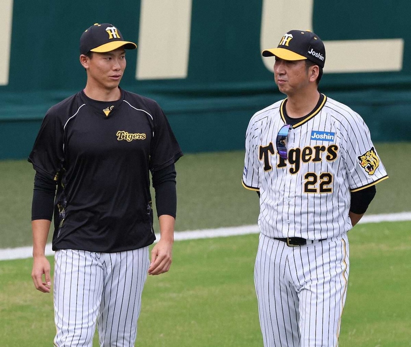 10月、甲子園球場で阪神・湯浅（左）と話す藤川監督