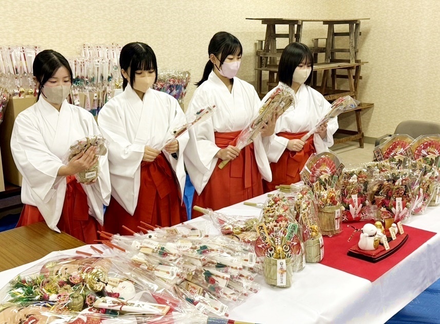 縁起物を手に取って点検する巫女＝島根県津和野町後田、太皷谷稲成神社