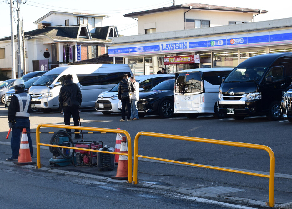 コンビニ越しに富士山を望む構図がＳＮＳで人気を集め、外国人観光客らが殺到している山梨県富士河口湖町の撮影スポットで１６日、横断防止用の柵をコンビニ側の歩道沿いに新設する工事が行われた＝同日午後