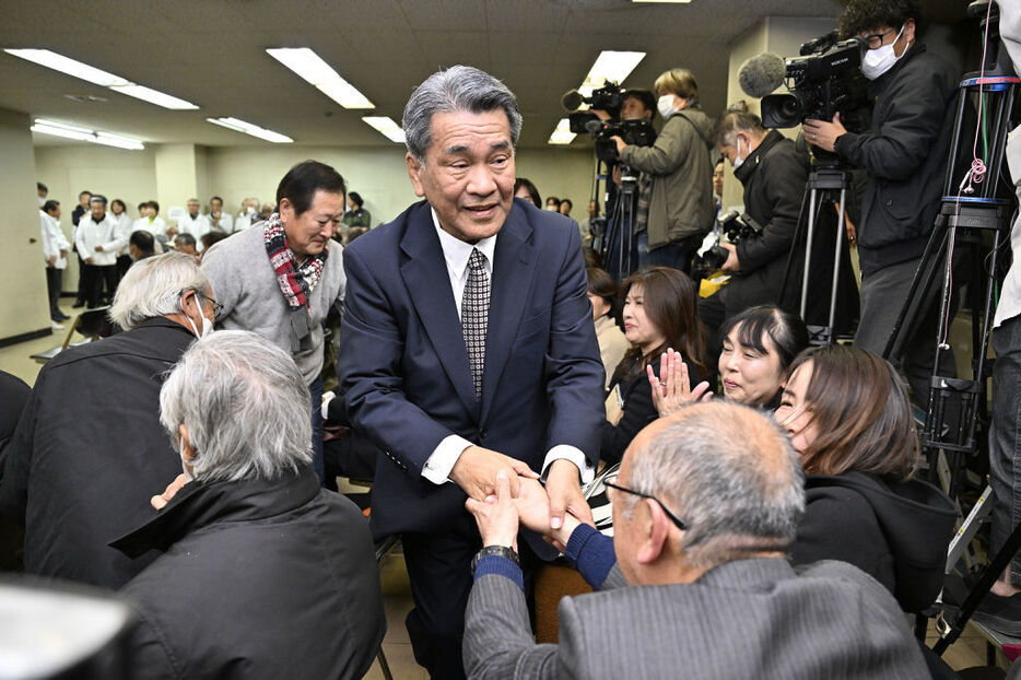 支援者と握手を交わして当選を喜ぶ中野弘道氏（中央）＝15日午後10時22分、焼津市