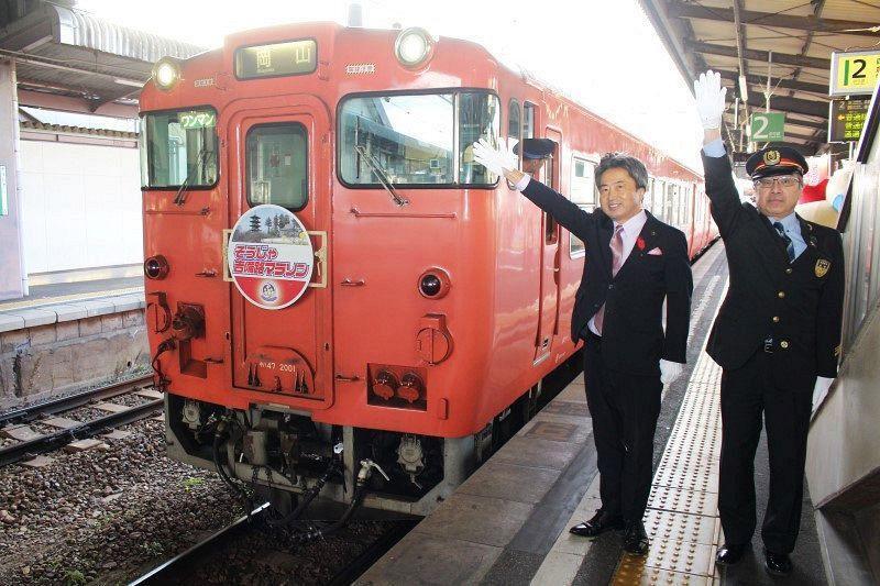 PR列車に出発の合図を出す片岡市長（左）ら＝総社駅