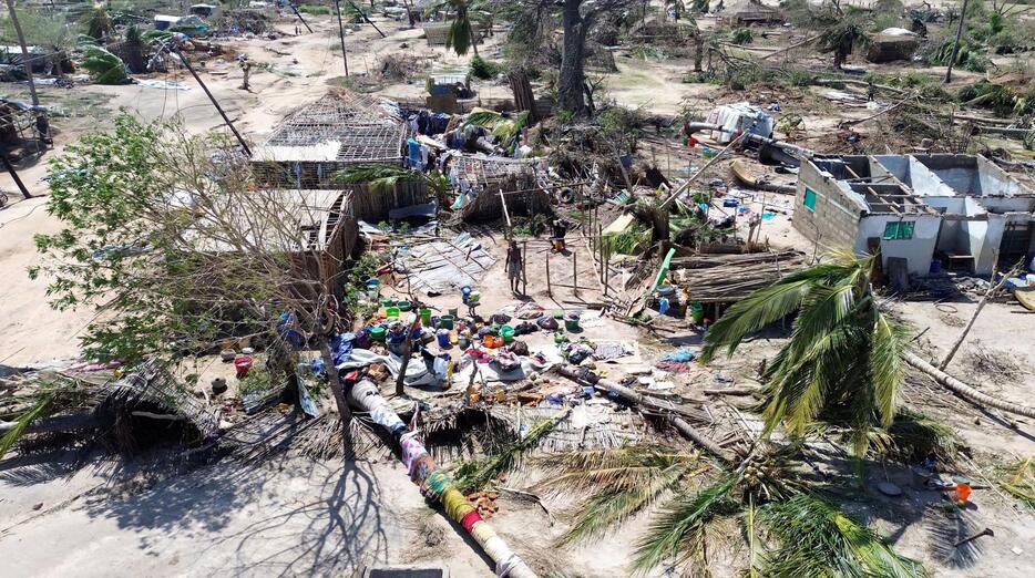 サイクロンが襲った後、倒れた木々やがれきの中に立つ人＝16日、モザンビーク北部（ユニセフ提供、ロイター＝共同）