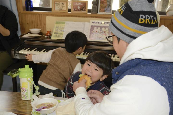 こども食堂＆おとな食堂で振る舞われたハンバーガーを頬張る子ども