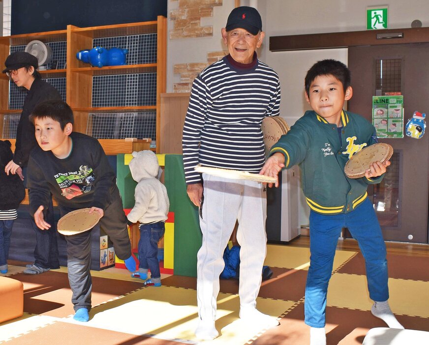 的をめがけて、高齢者とダンボールの円盤を投げ合う児童たち（福知山市猪崎・りとるハピネス）