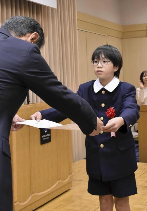 読書感想文コンクールで最高賞に輝き、表彰状を受け取る越智悠真さん＝8日午後、松山市大手町1丁目