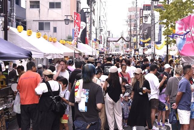 通りにびっしりと露店が並び、駐車場などあちこちで野外ライブなどのパフォーマンスが繰り広げられる。写真は2024年