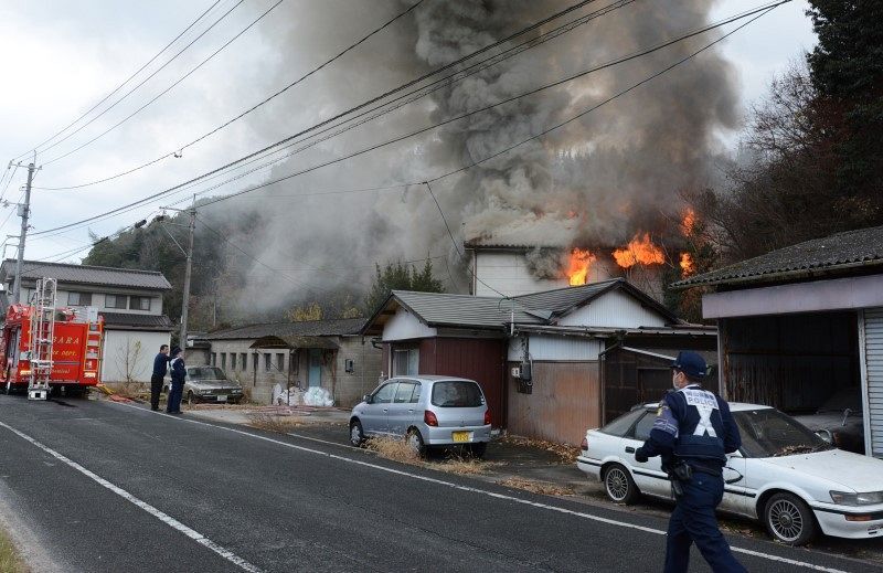 煙を上げて燃える民家＝31日午前11時7分