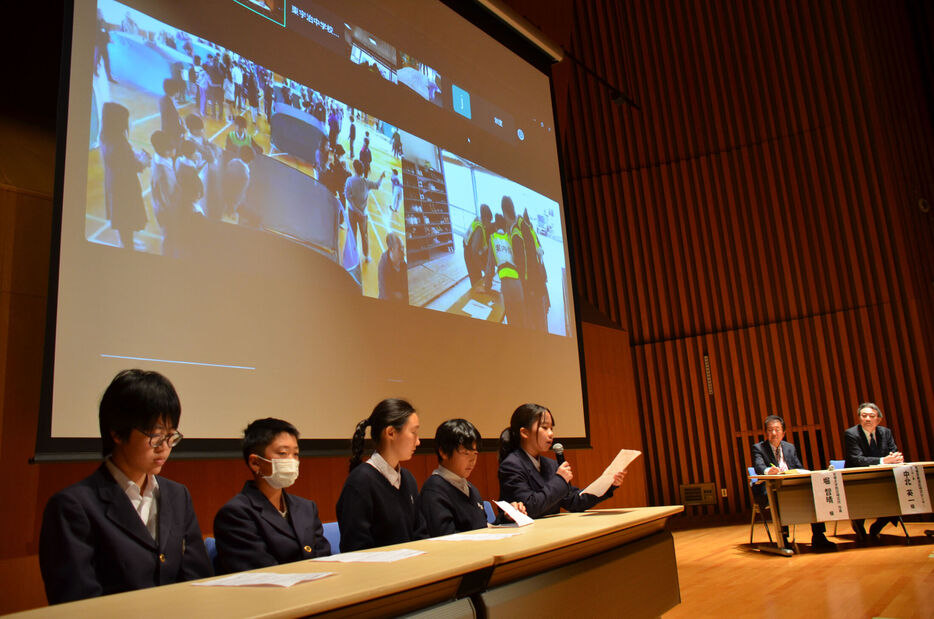 避難所開設訓練の様子をスクリーンに映し、解説する東宇治中の１年生ら（宇治市五ケ庄・きはだホール）