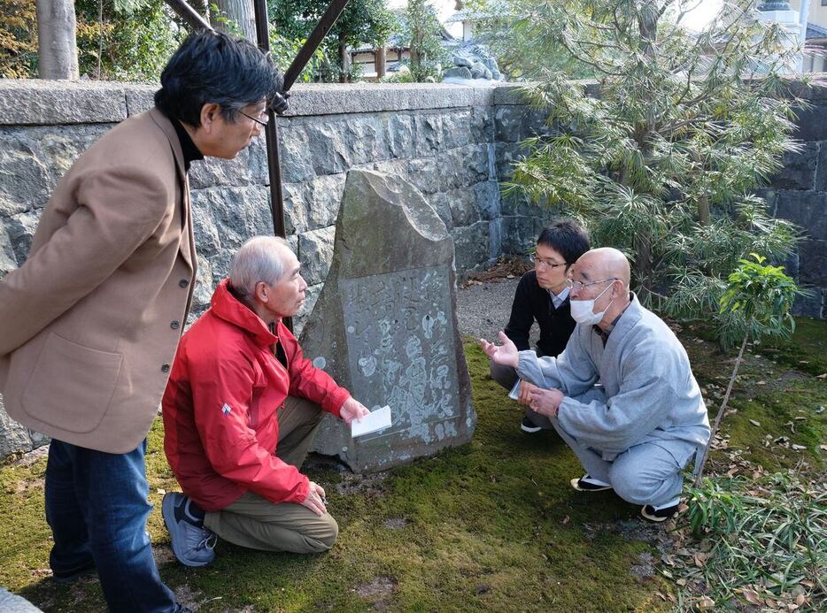 齢仙寺の後藤慶裕住職（右端）から供養碑の成り立ちについて聞き取り調査をする琵琶湖博物館の大河原秀康フィールドレポーター（左から2人目）ら＝滋賀県東近江市