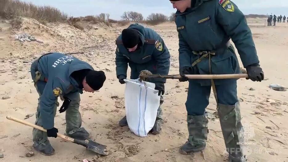 黒海沿岸で漂着した重油の除去作業に当たる人々。ロシア非常事態省提供の動画より（2024年12月17日提供）。【翻訳編集】 AFPBB News