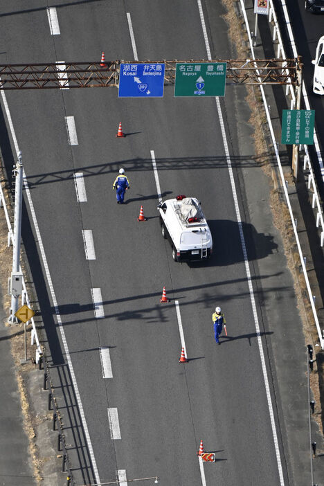 実況見分のため、事故現場近くで交通規制をする警察官＝30日午前11時36分、浜松市中央区篠原町（本社ヘリ「ジェリコ1号」から）