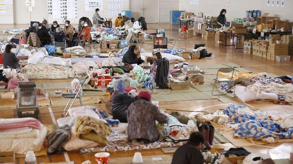 能登半島地震で避難所となった小学校の体育館で過ごす人たち。被災から時間がたっても十分な生活環境が整わなかった＝2024年1月12日、石川県輪島市（共同）