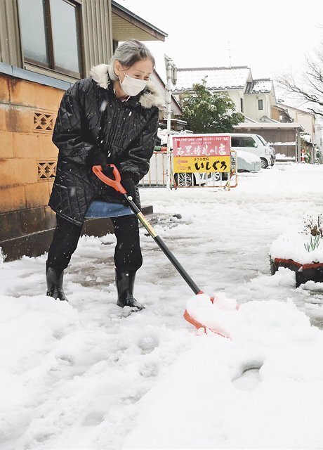 自宅前の除雪に追われる住民 ＝２８日午前１１時ごろ、富山市長柄町