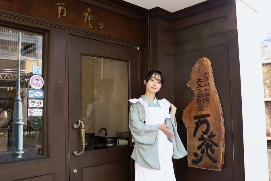 東北最古の喫茶店と言われる「土手の珈琲屋万茶ン」の前に立つ木下郁さん＝11月、青森県弘前市